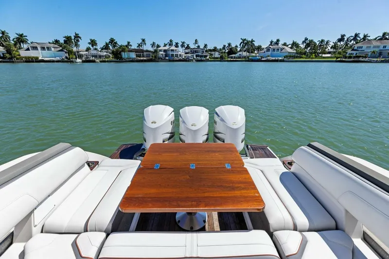 Luna B Yacht Photos Pics 2018 Tiara Yachts 38 LS with seating and table, overlooking serene waterfront homes.