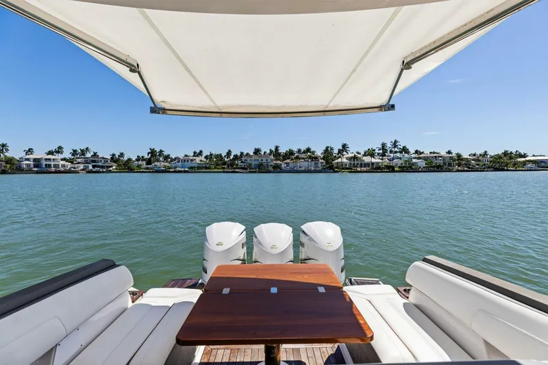 Luna B Yacht Photos Pics 2018 Tiara Yachts 38 LS with canopy, overlooking serene waterfront homes.