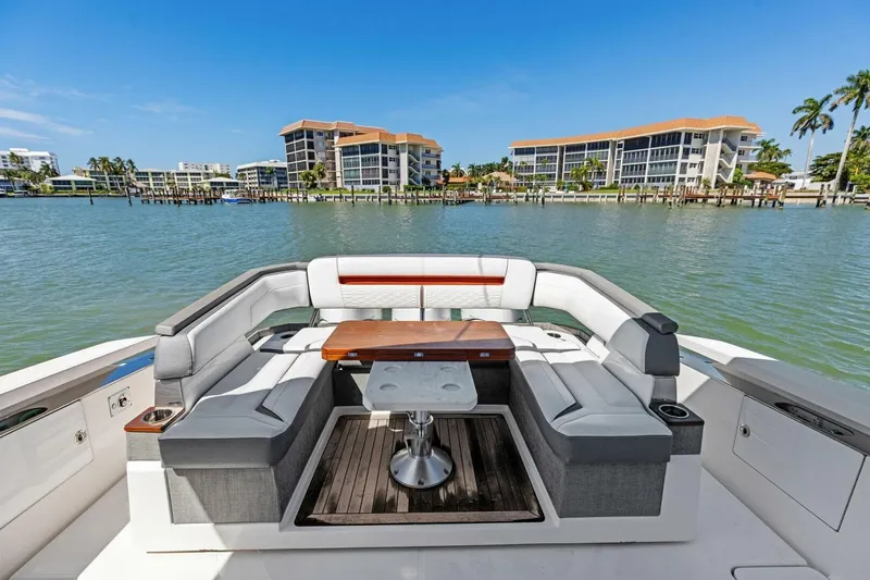 Luna B Yacht Photos Pics 2018 Tiara Yachts 38 LS with luxurious seating, docked near waterfront buildings.