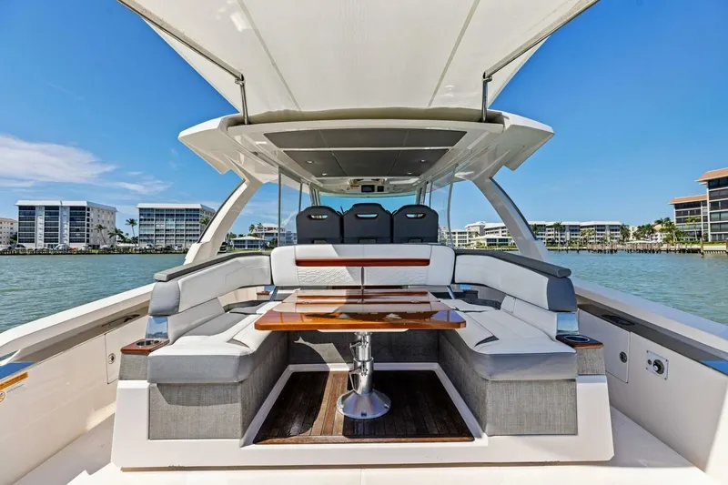 Luna B Yacht Photos Pics 2018 Tiara Yachts 38 LS luxury boat interior with seating and table, docked near waterfront buildings.