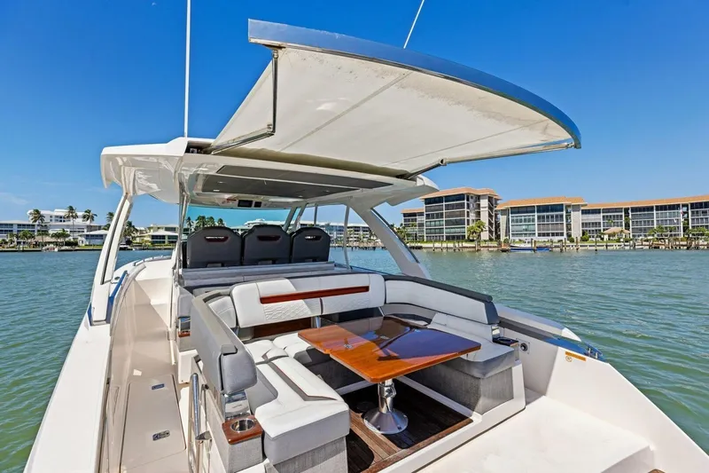Luna B Yacht Photos Pics 2018 Tiara Yachts 38 LS with spacious seating and table, docked near waterfront buildings.