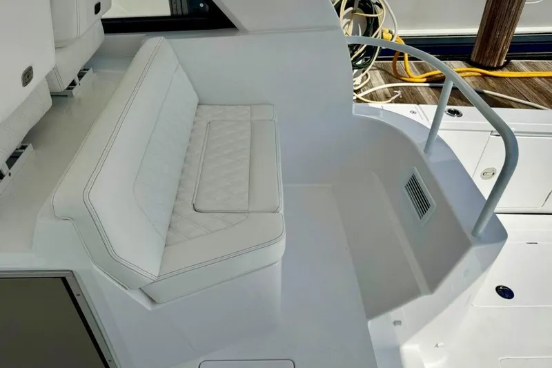  Yacht Photos Pics 2026 Intrepid 50 boat interior with white cushioned seating and sleek design.