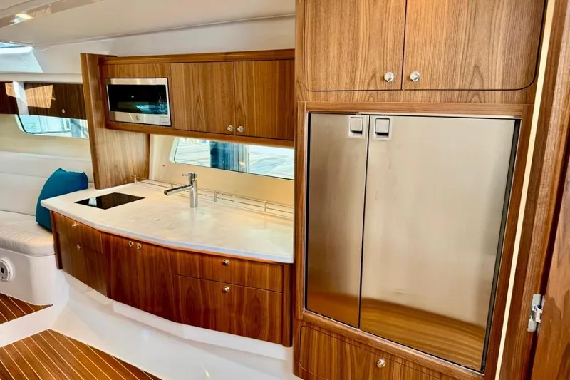  Yacht Photos Pics Luxurious 2026 Intrepid 50 yacht interior with modern kitchen and wood cabinetry.