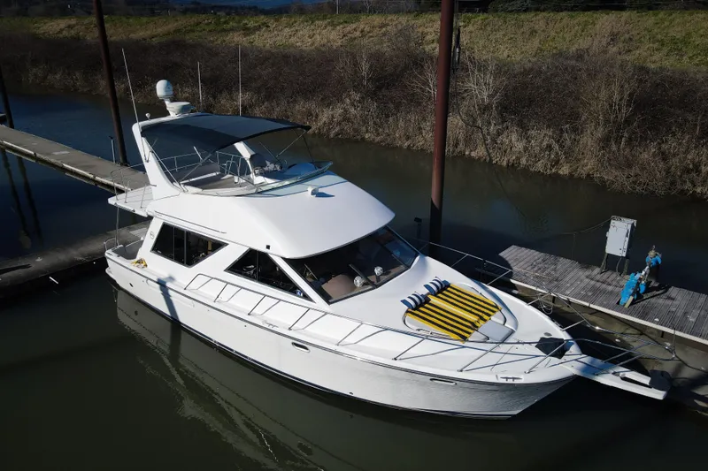  Yacht Photos Pics 2002 Bayliner 3988 Command Bridge Motoryacht docked in a serene marina setting.