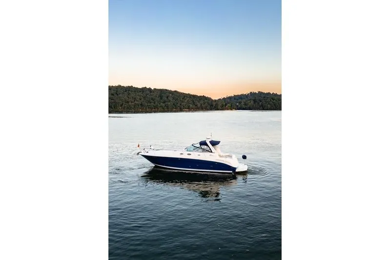 Murphys Law Yacht Photos Pics 2004 Sea Ray 380 Sundancer yacht cruising on a serene lake at sunset.