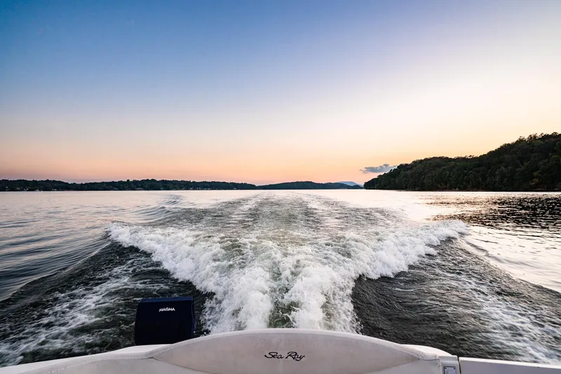 Murphys Law Yacht Photos Pics Wake behind a 2004 Sea Ray 380 Sundancer at sunset on a serene lake.