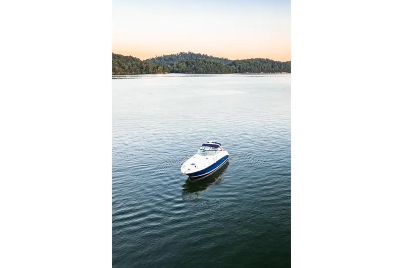 Murphys Law Yacht Photos Pics 2004 Sea Ray 380 Sundancer yacht on calm water with forested shoreline.