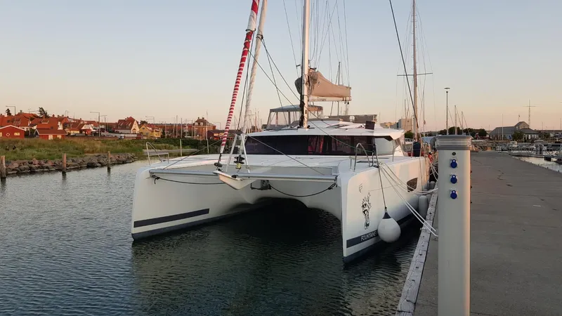 Super Trouper Yacht Photos Pics 2019 Fountaine Pajot Saona 47 catamaran docked in a serene marina setting.