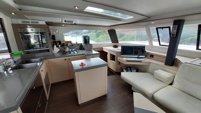 Super Trouper Yacht Photos Pics Luxurious interior of 2019 Fountaine Pajot Saona 47 catamaran with modern kitchen and seating area.