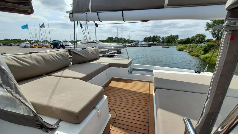 Super Trouper Yacht Photos Pics Spacious deck of 2019 Fountaine Pajot Saona 47 catamaran with comfortable seating and scenic marina view.