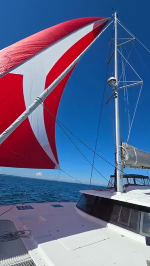 Super Trouper Yacht Photos Pics Sailing catamaran Fountaine Pajot Saona 47 with red sail on open sea, 2019 model.