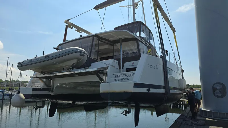 Super Trouper Yacht Photos Pics 2019 Fountaine Pajot Saona 47 catamaran lifted at marina, featuring a dinghy on davits.
