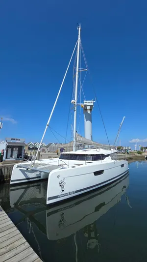 Super Trouper Yacht Photos Pics 2019 Fountaine Pajot Saona 47 catamaran docked in a marina under clear blue skies.