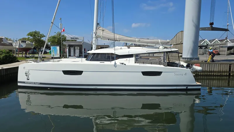 Super Trouper Yacht Photos Pics 2019 Fountaine Pajot Saona 47 catamaran docked in a marina, reflecting on calm water.