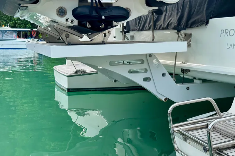 Promprang Yacht Photos Pics Lagoon 50 catamaran's hydraulic platform and ladder, 2020 model, on calm green water.