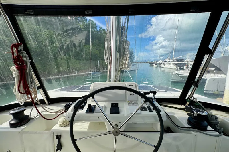 Promprang Yacht Photos Pics Cockpit view of 2020 Lagoon 50 catamaran in marina, featuring steering wheel and controls.