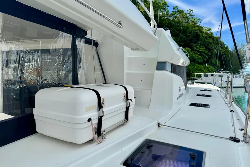 Promprang Yacht Photos Pics 2020 Lagoon 50 yacht deck with safety equipment, docked near lush greenery.