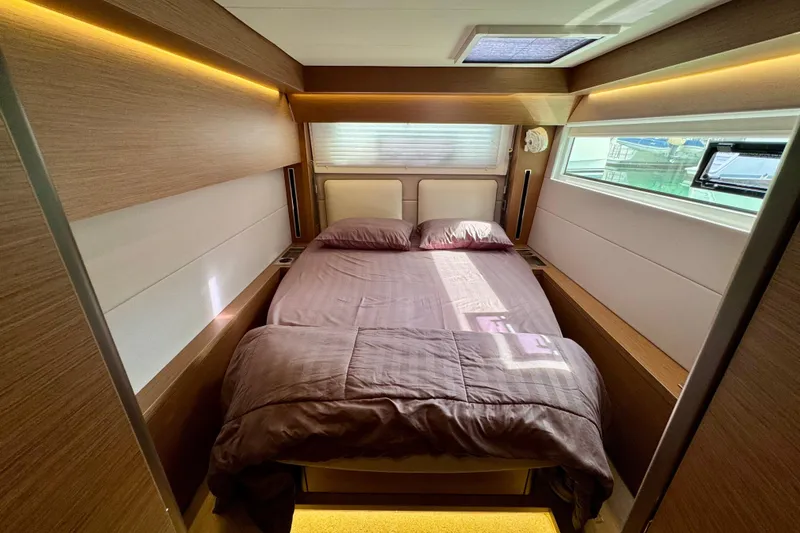 Promprang Yacht Photos Pics Luxurious bedroom interior of 2020 Lagoon 50 yacht with modern wood paneling and cozy bedding.