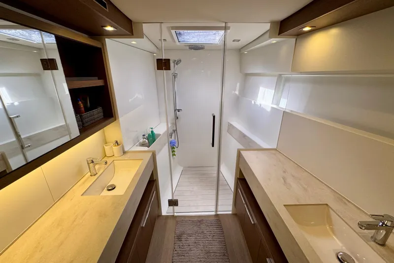 Promprang Yacht Photos Pics Luxurious bathroom interior of 2020 Lagoon 50 yacht with dual sinks and glass shower.
