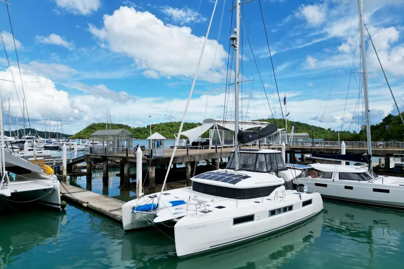Promprang Yacht Photos Pics 2020 Lagoon 50 catamaran docked at a marina under a bright blue sky.
