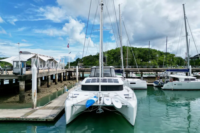 Promprang Yacht Photos Pics 2020 Lagoon 50 catamaran docked at marina with clear skies and lush greenery.