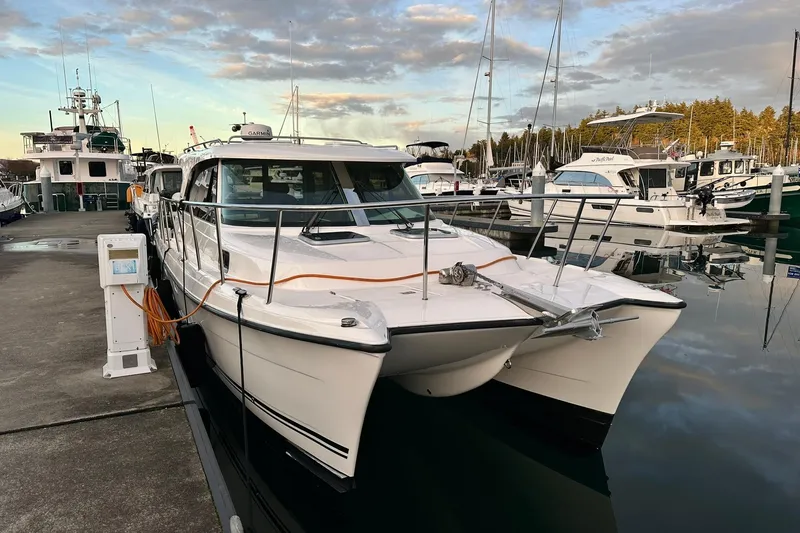  Yacht Photos Pics 2021 Aspen C108 boat docked at marina, surrounded by other vessels under a cloudy sky.