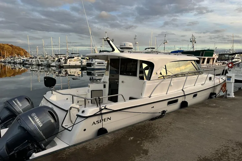 Yacht Photos Pics 2021 Aspen C108 boat docked at marina with Yamaha engines, under cloudy sky.