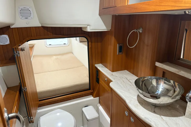  Yacht Photos Pics Luxurious Aspen C108 2021 yacht interior with wooden cabinetry, modern sink, and cozy sleeping area.