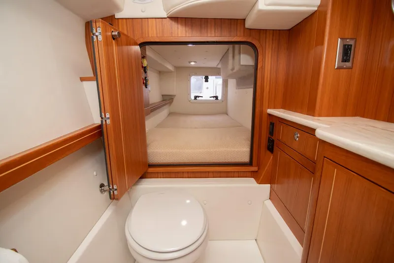  Yacht Photos Pics Luxurious Aspen C108 2021 yacht interior with wooden cabinetry and compact bathroom.