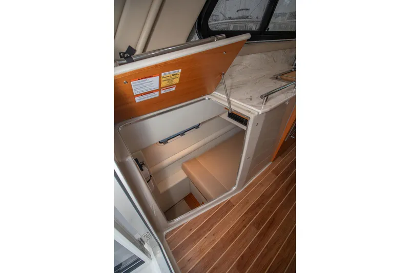  Yacht Photos Pics 2021 Aspen C108 boat interior storage compartment with wooden flooring and cushioned seating.