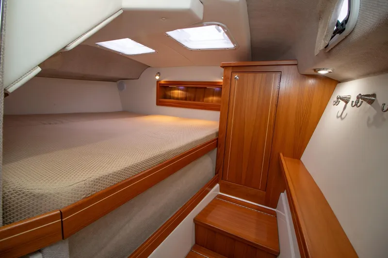  Yacht Photos Pics Luxurious cabin interior of 2021 Aspen C108 boat with wooden finishes and cozy bed.