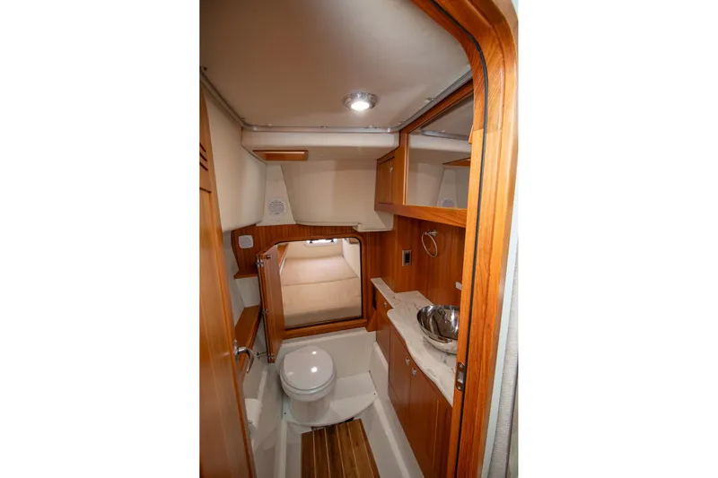  Yacht Photos Pics 2021 Aspen C108 boat interior bathroom with wooden cabinetry and modern fixtures.