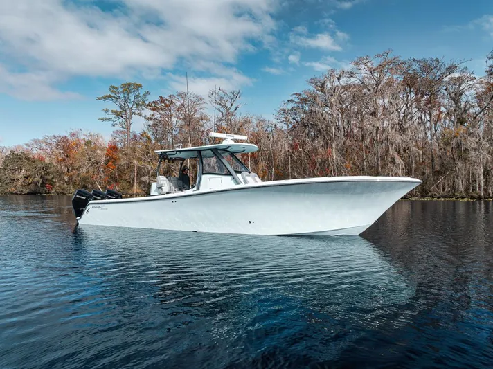One Time Yacht Photos Pics 2024 Front Runner 36 Center Console boat on a serene lake with autumn trees.