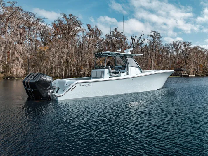 One Time Yacht Photos Pics 2024 Front Runner 36 Center Console boat on a serene lake with trees in the background.