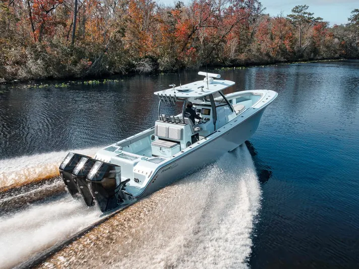 One Time Yacht Photos Pics 2024 Front Runner 36 Center Console boat cruising on a scenic river with autumn foliage.