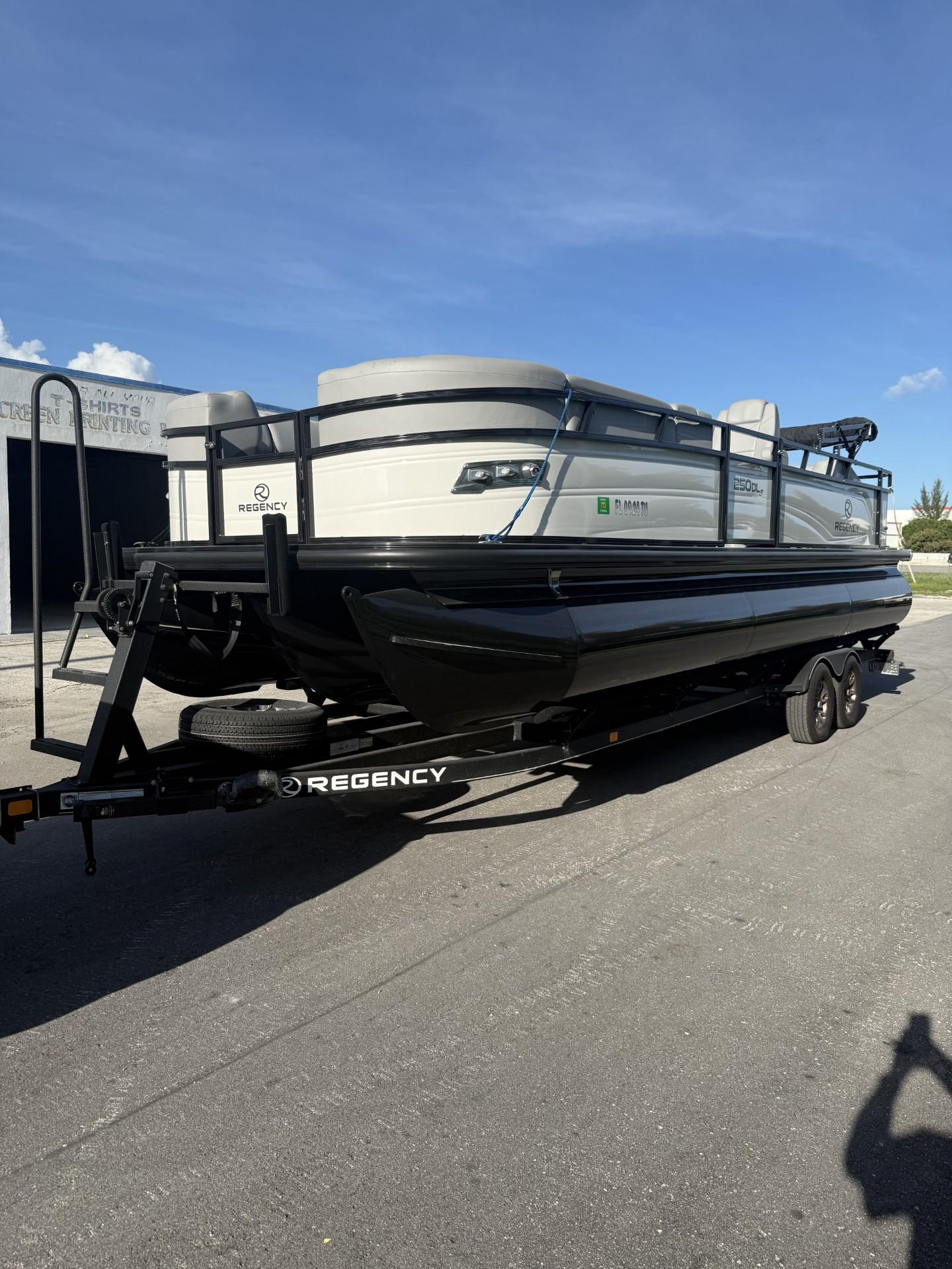 2024 Regency 250 DL3 pontoon boat on trailer under clear blue sky.