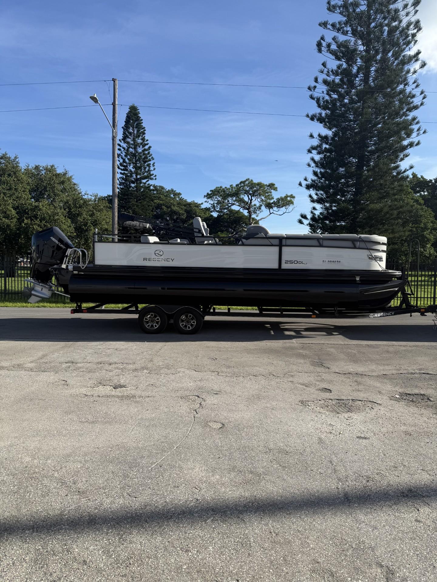 2024 Regency 250 DL3 pontoon boat on trailer, parked outdoors.