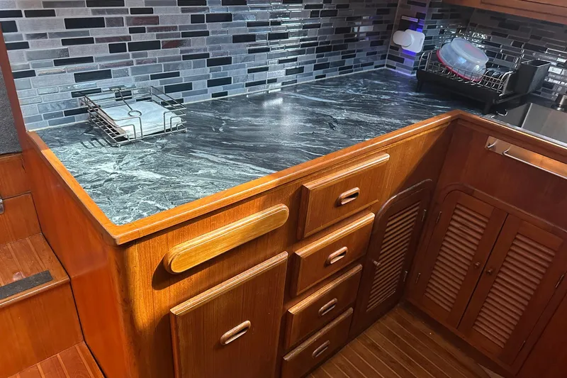 Off Ramp Yacht Photos Pics 2002 Novatec Sundeck kitchen with wooden cabinets and modern tile backsplash.