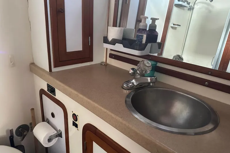 Off Ramp Yacht Photos Pics Bathroom sink area on a 2002 Novatec Sundeck yacht, featuring a countertop and mirror.