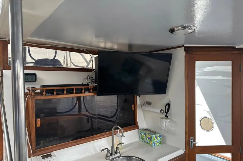 Off Ramp Yacht Photos Pics Interior of 2002 Novatec Sundeck yacht with TV, sink, and wooden accents.