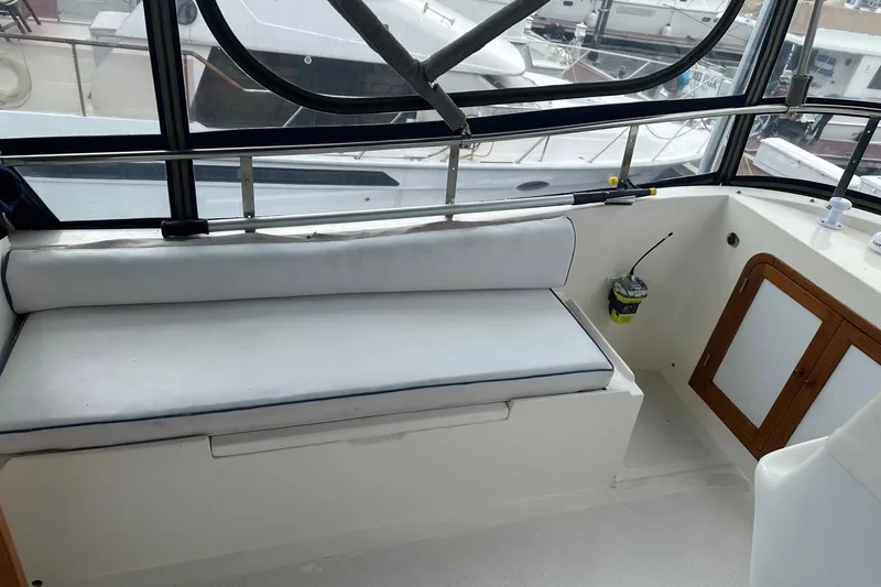 Off Ramp Yacht Photos Pics 2002 Novatec Sundeck interior with white seating and wooden cabinet.