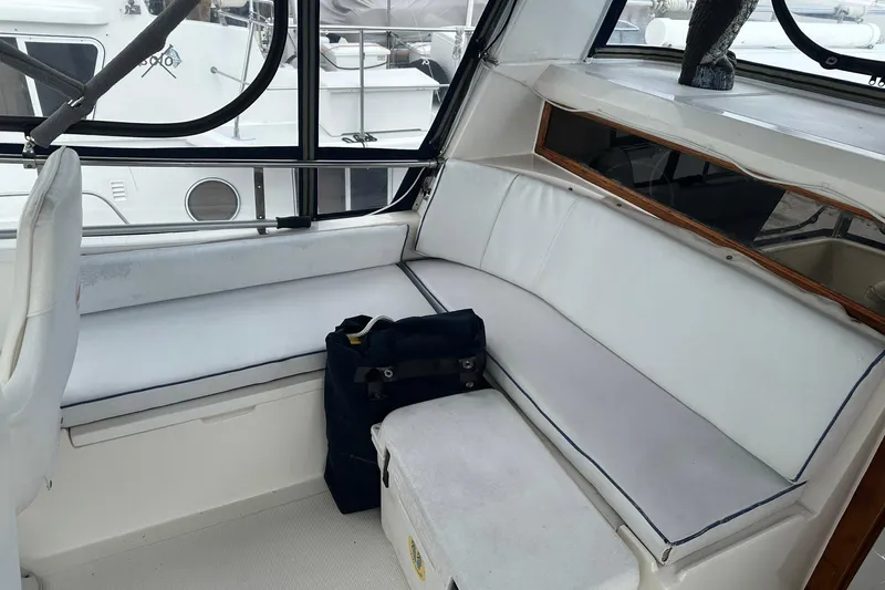 Off Ramp Yacht Photos Pics Interior of 2002 Novatec Sundeck yacht with white seating and windows.