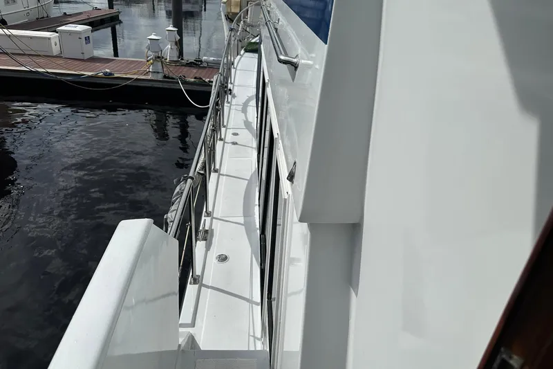 Off Ramp Yacht Photos Pics 2002 Novatec Sundeck yacht docked at marina, side view with railing and water.