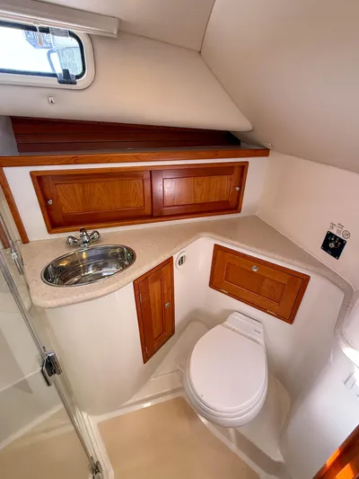 Wild Rose Yacht Photos Pics 2015 MJM 36z Downeast yacht bathroom with sink, toilet, and wooden cabinets.