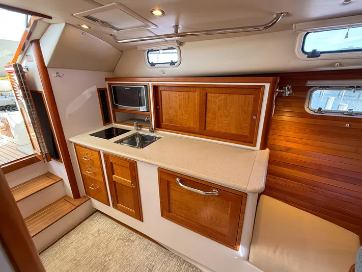 Wild Rose Yacht Photos Pics 2015 MJM 36z Downeast yacht interior with wooden cabinetry and compact kitchen area.