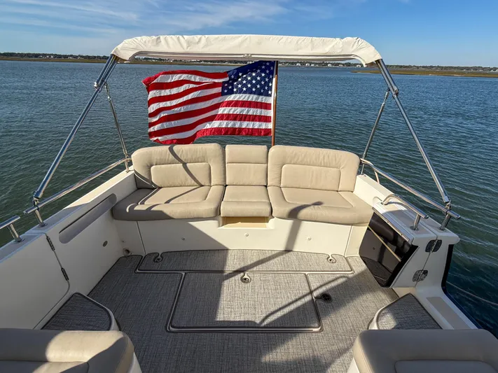 Wild Rose Yacht Photos Pics 2015 MJM 36z Downeast boat with American flag, beige seating, and calm waters.