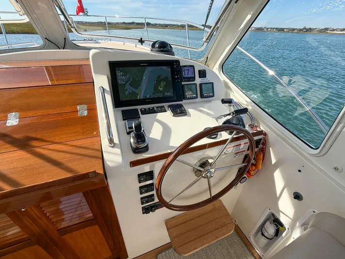 Wild Rose Yacht Photos Pics 2015 MJM 36z Downeast helm with wooden wheel and navigation display on calm waters.
