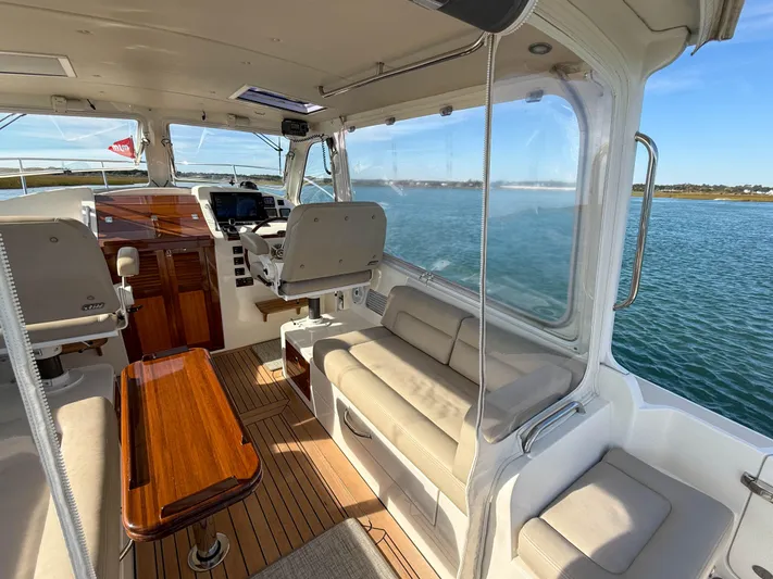Wild Rose Yacht Photos Pics Interior of 2015 MJM 36z Downeast boat with seating and helm, overlooking water.