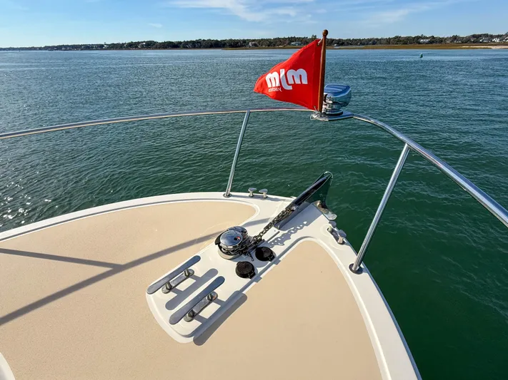 Wild Rose Yacht Photos Pics 2015 MJM 36z Downeast boat bow with red flag on calm water.