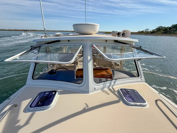 Wild Rose Yacht Photos Pics 2015 MJM 36z Downeast boat cruising on calm waters, open windows, clear sky.